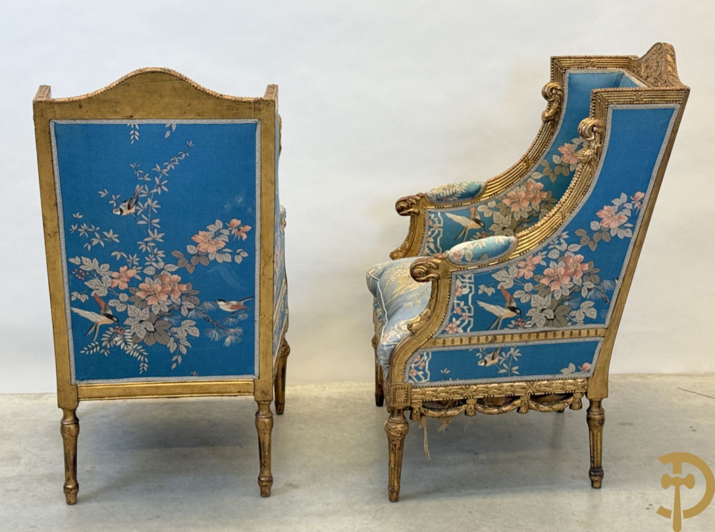 Twee vergulde bergères met gesculpteerde accanthusranken en guirlandes