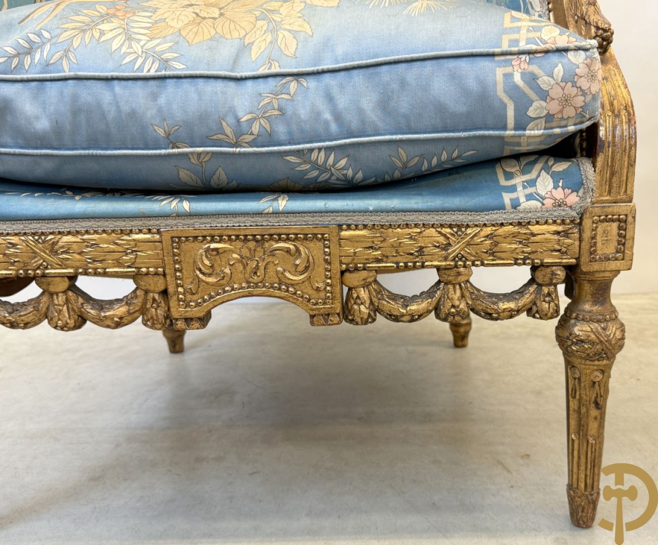 Twee vergulde bergères met gesculpteerde accanthusranken en guirlandes