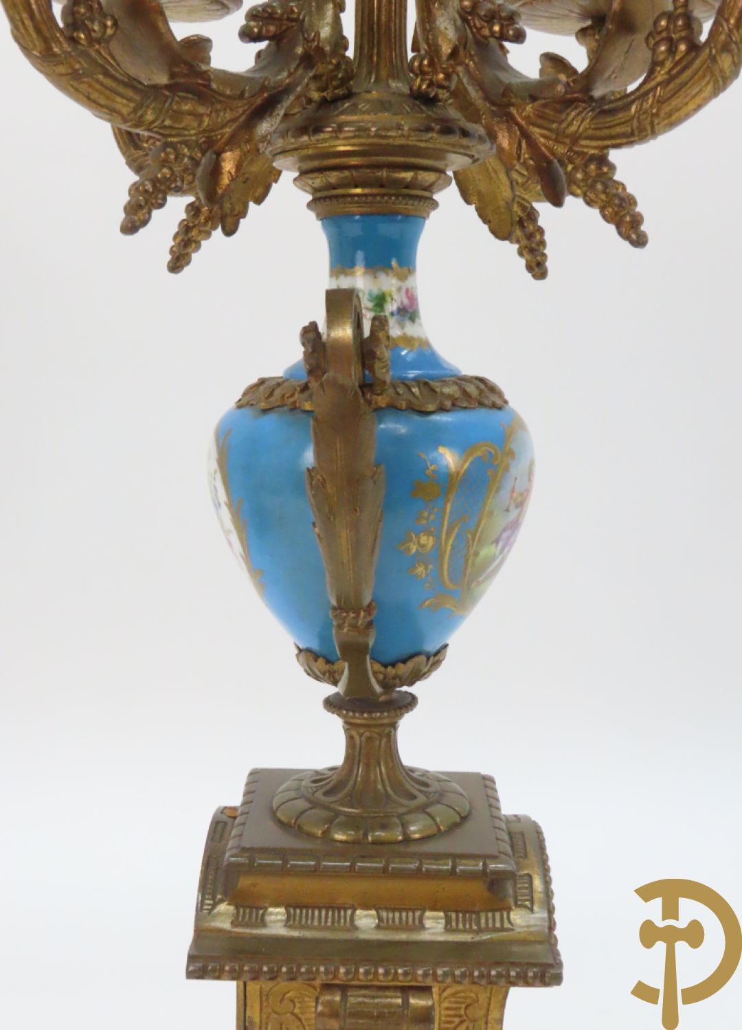 Driedelige bronzen garnituur bezet met Sèvres porselein bestaande uit pendule geflankeerd door paar cupido