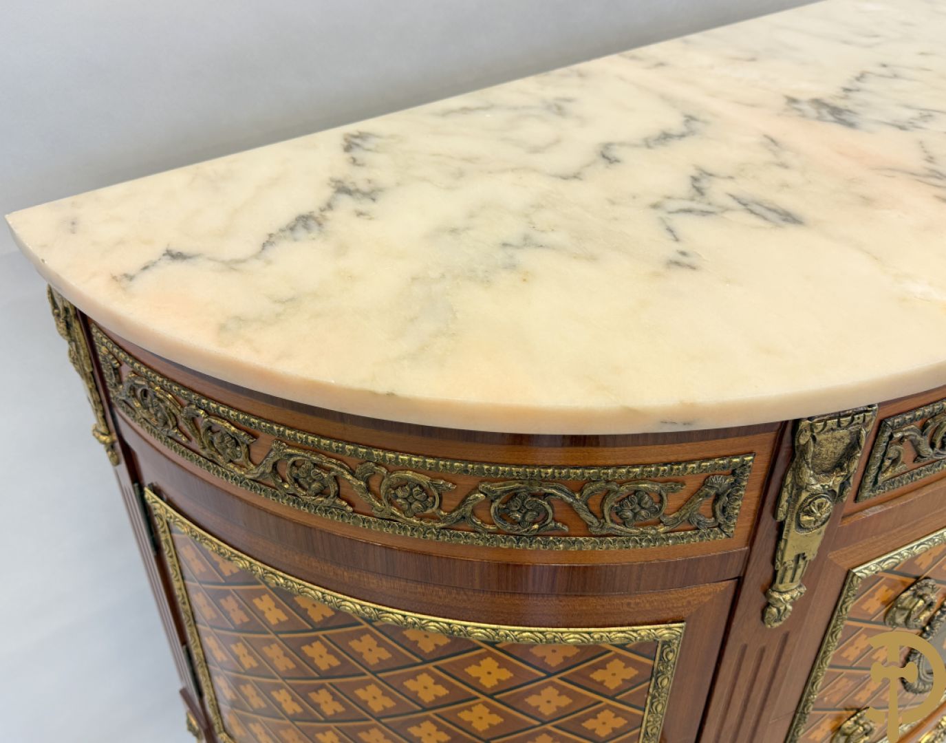 Halve maanvormige drieladencommode met 2 zijdelingse deuren, gemarketteerde bloemenmotieven en bronzen ornamenten, bovenaan bezet met marmeren blad