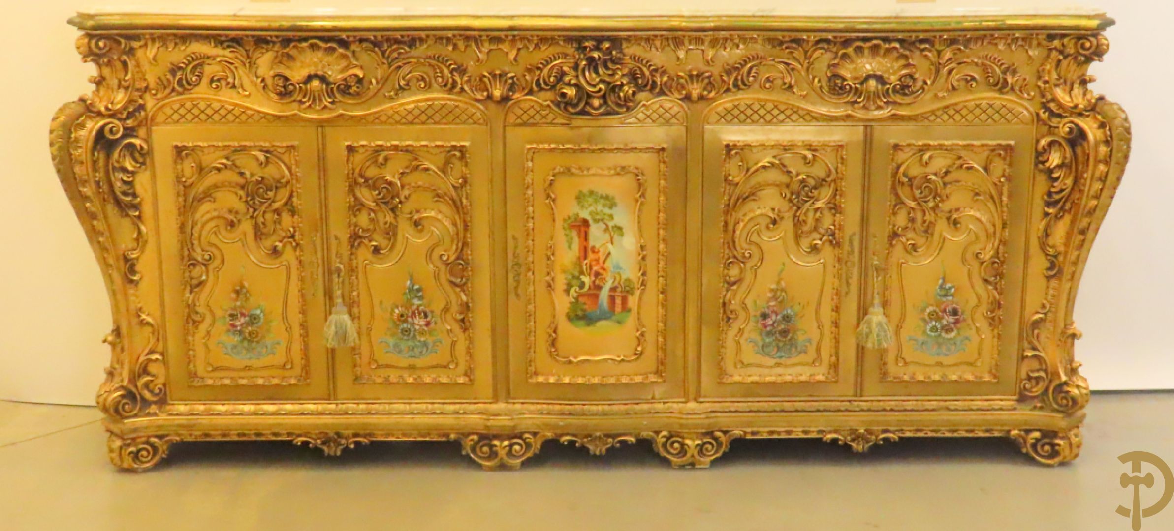 Uitzonderlijke vergulde Louis XV eetkamer bestaande uit vijfdeursdressoir met voluutvormige accanthusranken en rocailles, beschilderd met bloemenmotieven en centraal tafererel met hoornen des overvloeds + bijhorende spiegel vergulde tafel op voluutvormige poten met zes bijhorende stoelen + vitrine met accanthusranken en centrale deur, op voluutvormige poten