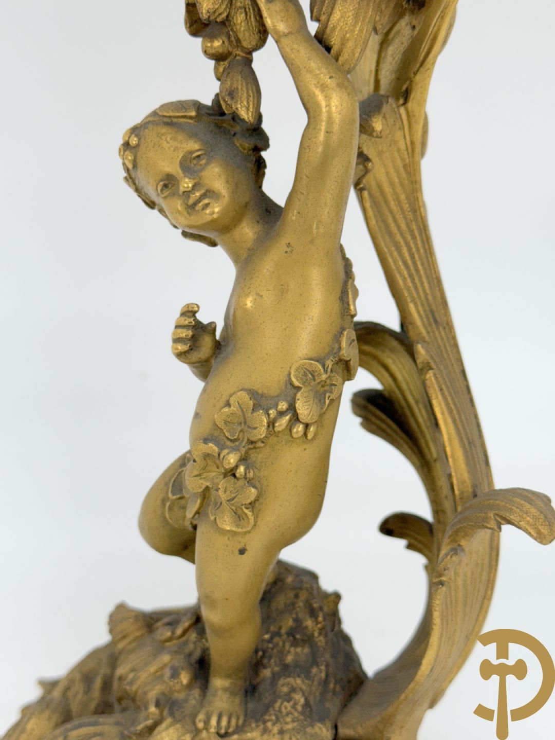 Driedelige vuurvergulde bronzen garnituur, Louis XV stijl, bestaande uit middenstuk met klok omgeven door musicerende cupido