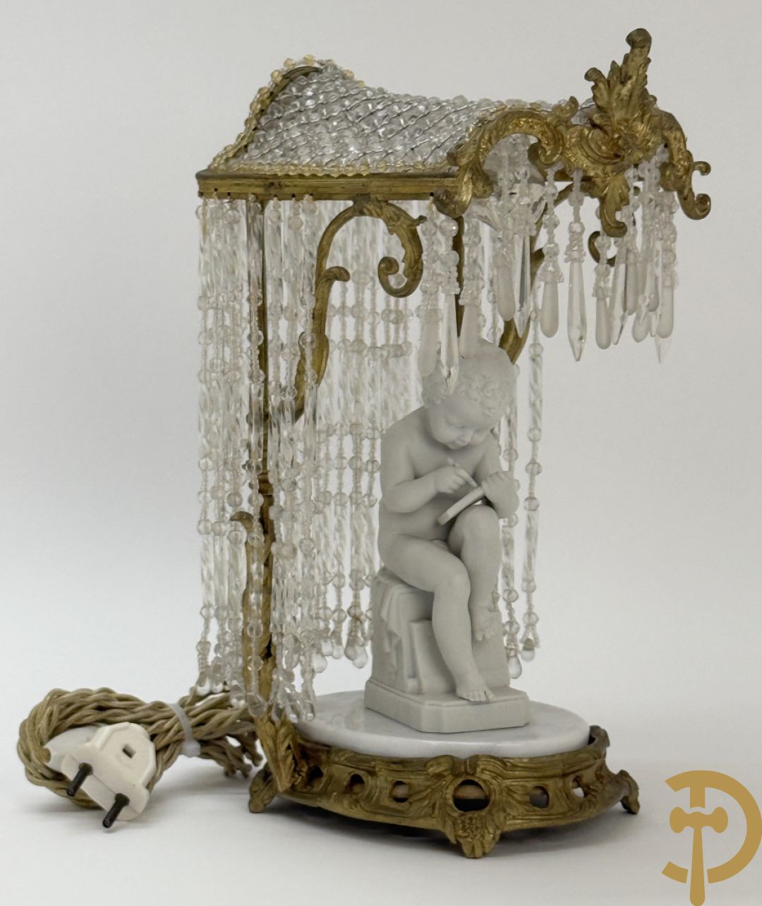 Biscuitbeeld van schrijvende cupido onder bronzen dakje met kristallen bellen bezet - op marmeren sokkel gemonteerd