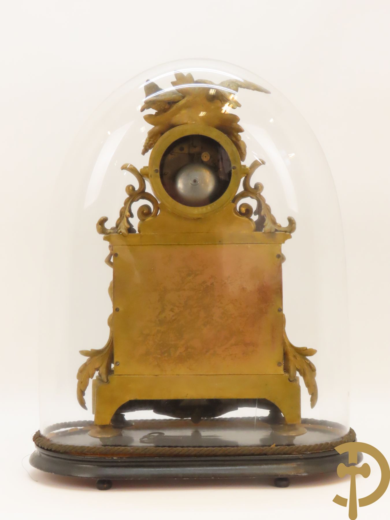 Vergulde pendule in zamak, wijzerplaat bezet met porseleinen plakkettes - bovenaan met vogelpaar, zijdelings met kariathyden houdende een bloementroffee - onder glazen stolp