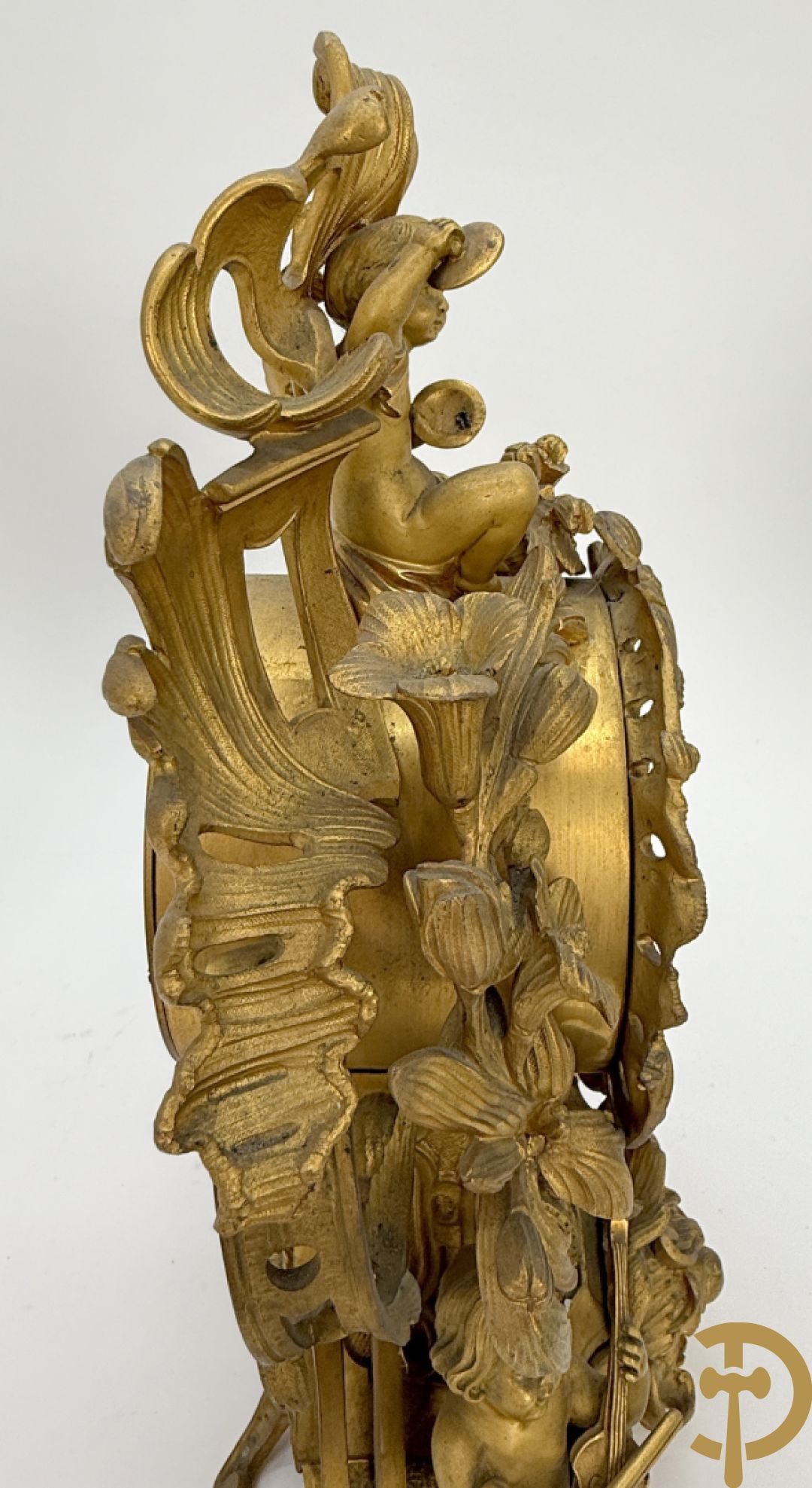 Driedelige vuurvergulde bronzen garnituur, Louis XV stijl, bestaande uit middenstuk met klok omgeven door musicerende cupido