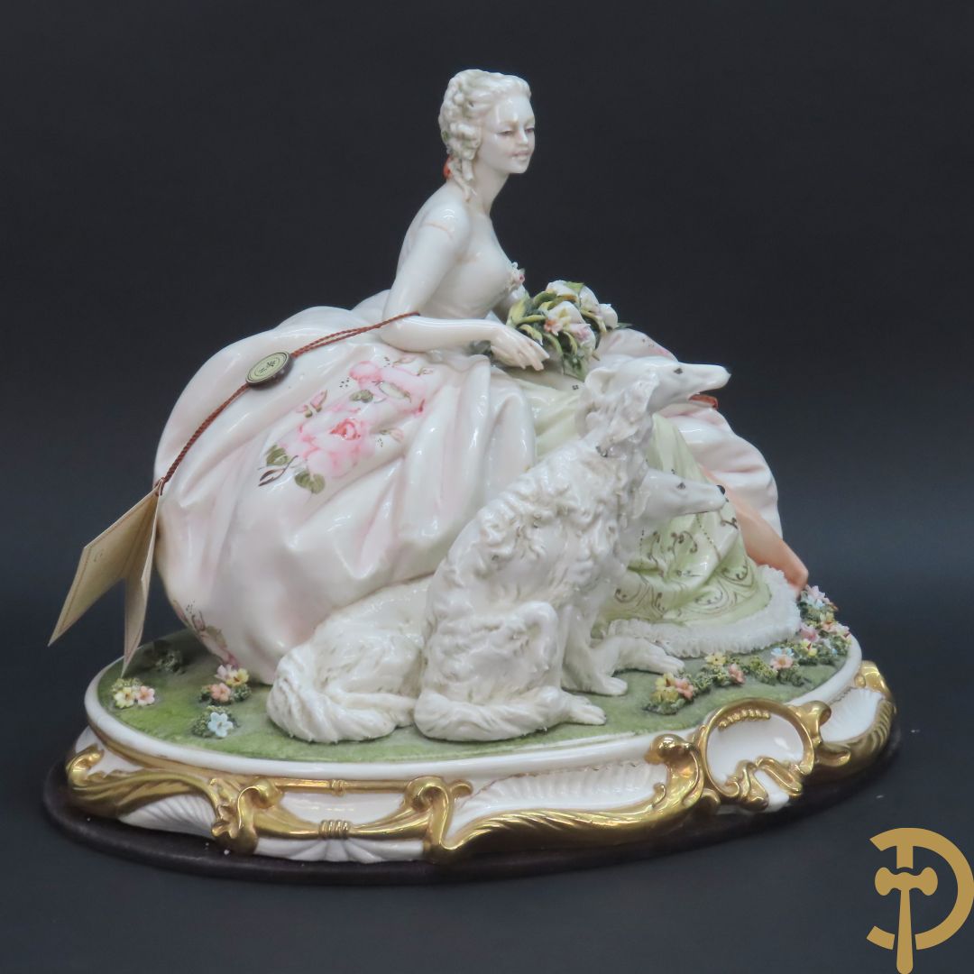 Italiaans porseleinen sierbeeld van zittende dame met 2 windhonden, L. Cazzola getekend en Capo di Monte gemerkt achteraan