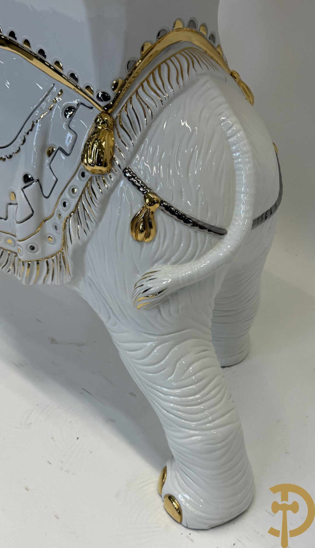 Porseleinen sierbeeld van olifant als staander met daarboven jongeman met bloemencachepot