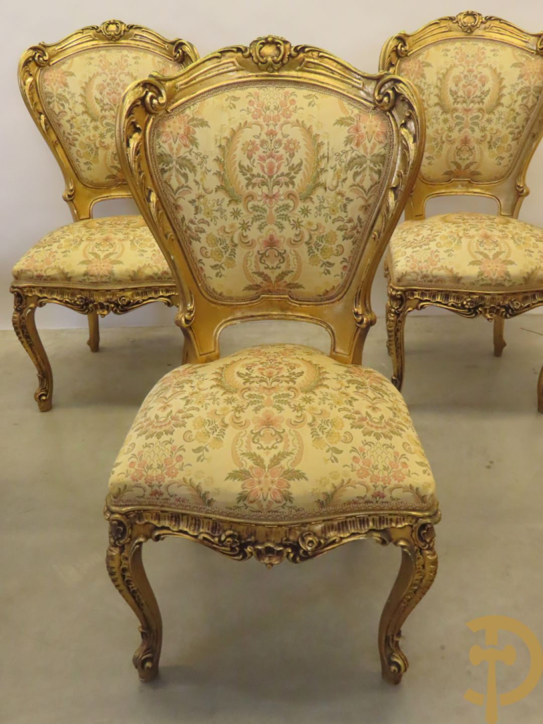 Uitzonderlijke vergulde Louis XV eetkamer bestaande uit vijfdeursdressoir met voluutvormige accanthusranken en rocailles, beschilderd met bloemenmotieven en centraal tafererel met hoornen des overvloeds + bijhorende spiegel vergulde tafel op voluutvormige poten met zes bijhorende stoelen + vitrine met accanthusranken en centrale deur, op voluutvormige poten