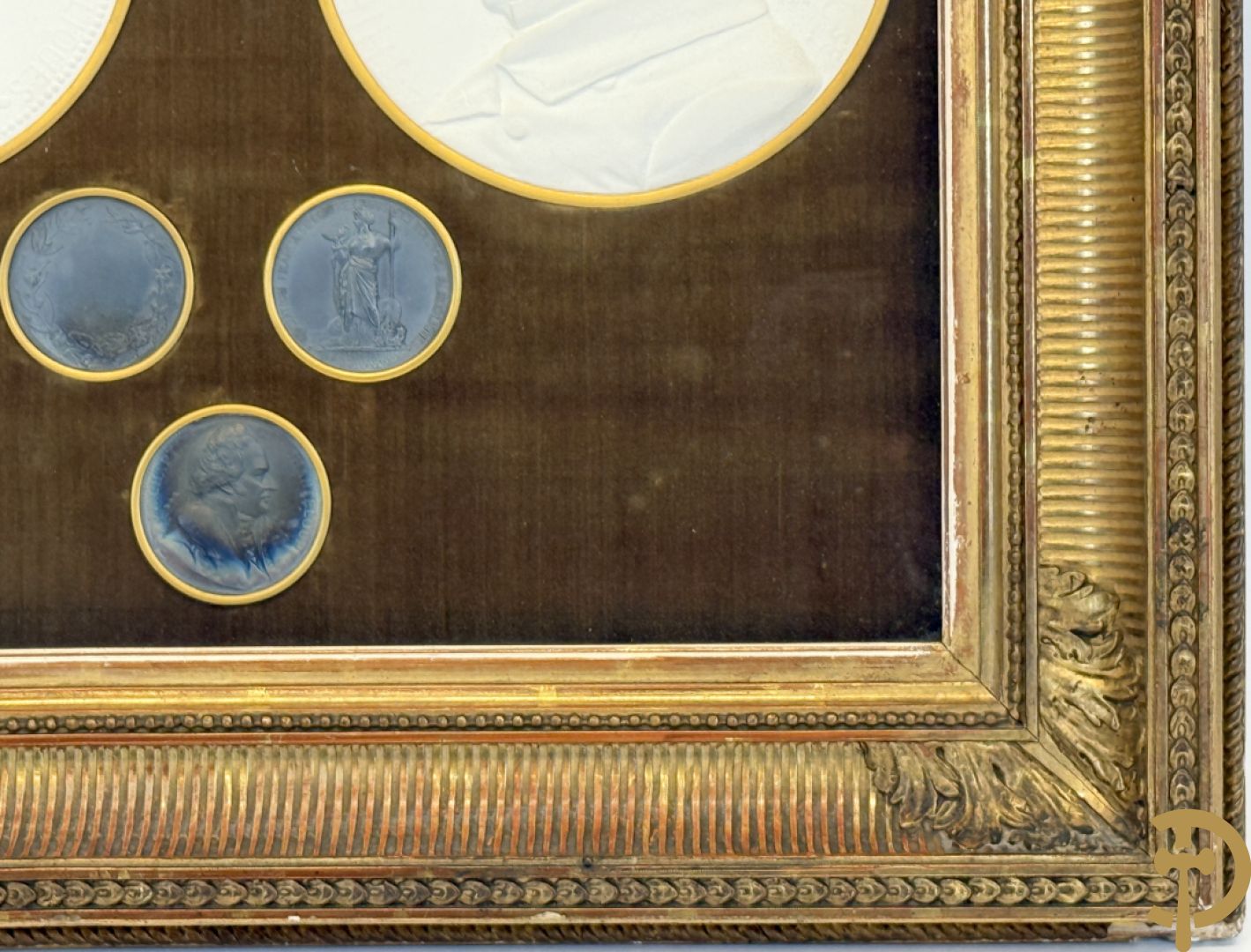 Kader met twee porseleinen plakkettes en 3 munten van Oudiné Eugène André
