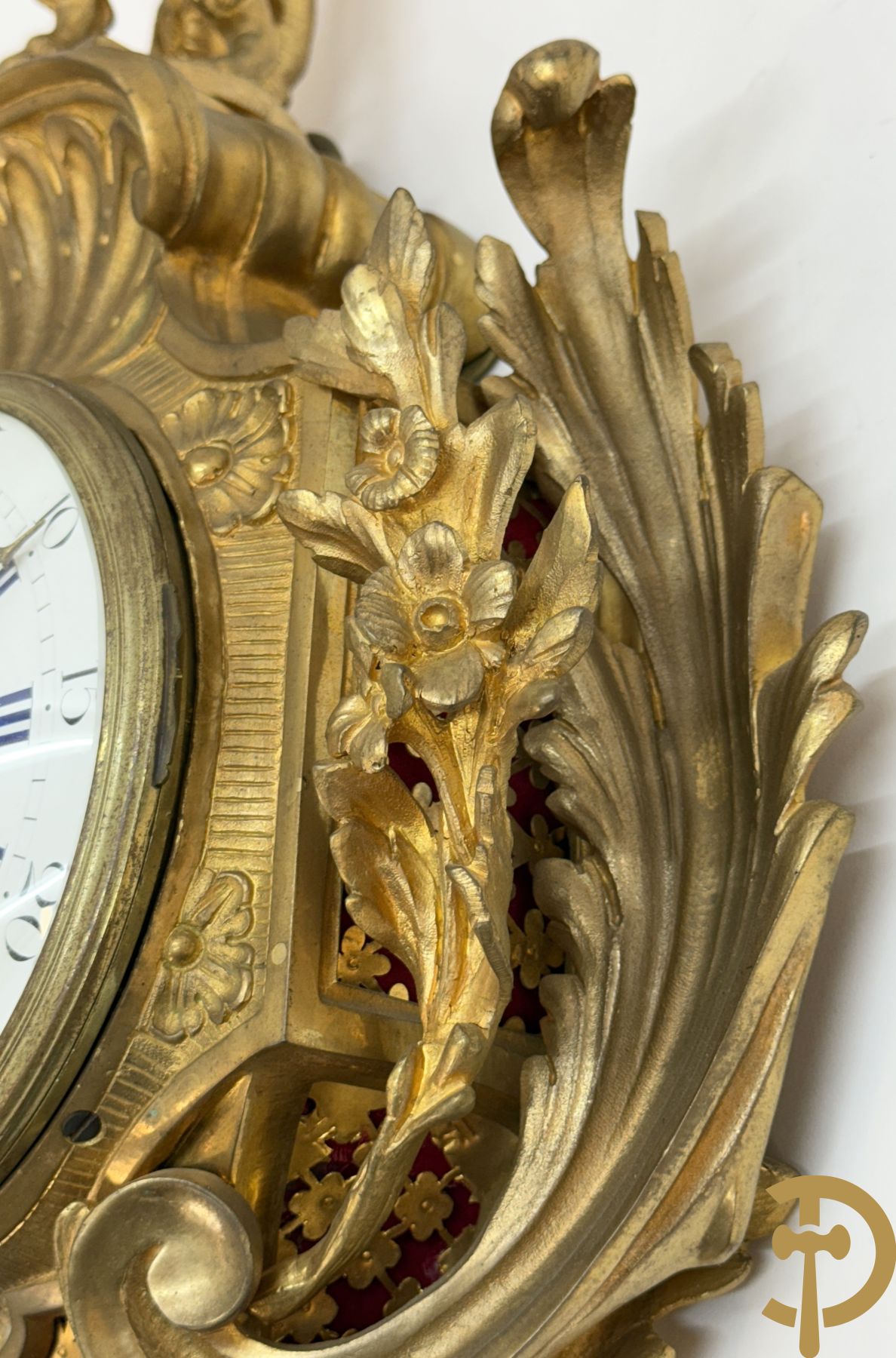 Bronzen muurkartel Louis XV stijl met bloemenmotieven en bovenaan bezet met faune met triangle, Molle Paris getekend binnenin op uurwerk