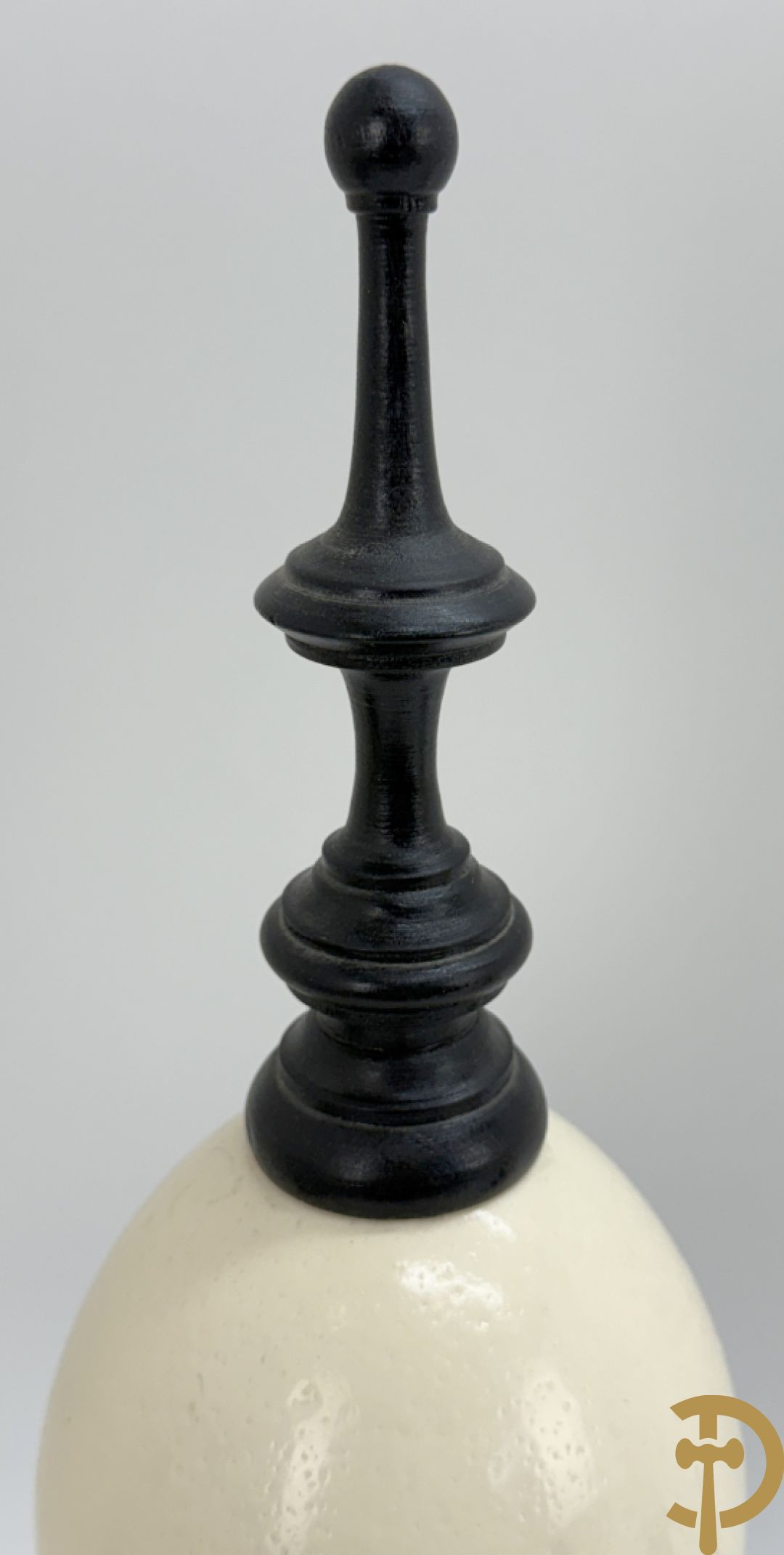 Vijf struisvogeleieren op zwart houten statief