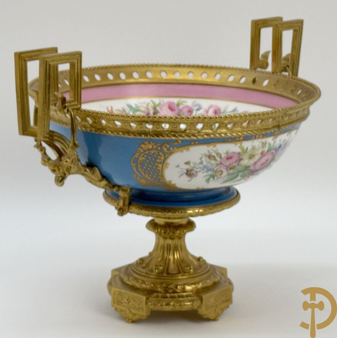 Porseleinen coupe met centraal tafereel en omringd met bloemendecor, gevat in bronzen houder