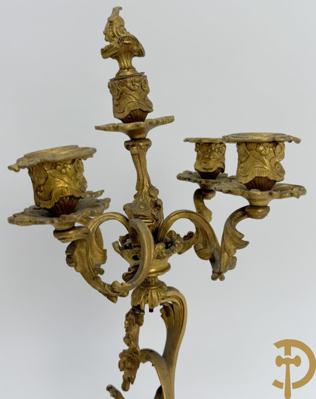 Driedelige vuurvergulde bronzen garnituur, Louis XV stijl, bestaande uit middenstuk met klok omgeven door musicerende cupido