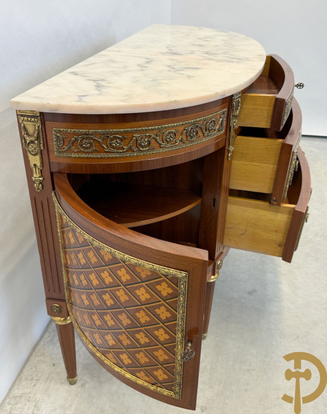 Halve maanvormige drieladencommode met 2 zijdelingse deuren, gemarketteerde bloemenmotieven en bronzen ornamenten, bovenaan bezet met marmeren blad