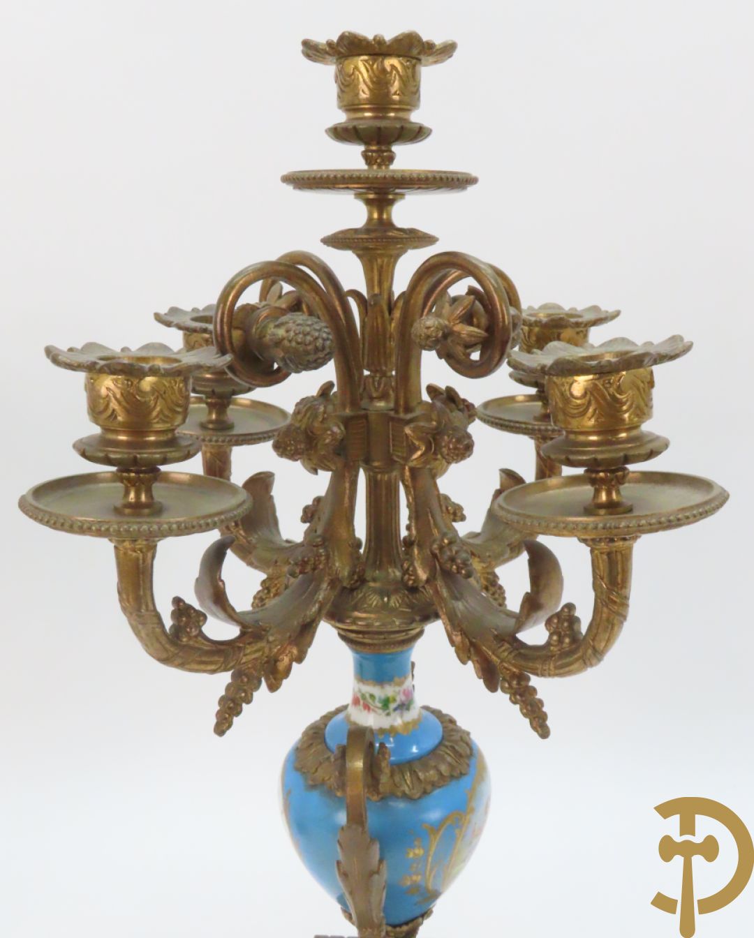 Driedelige bronzen garnituur bezet met Sèvres porselein bestaande uit pendule geflankeerd door paar cupido