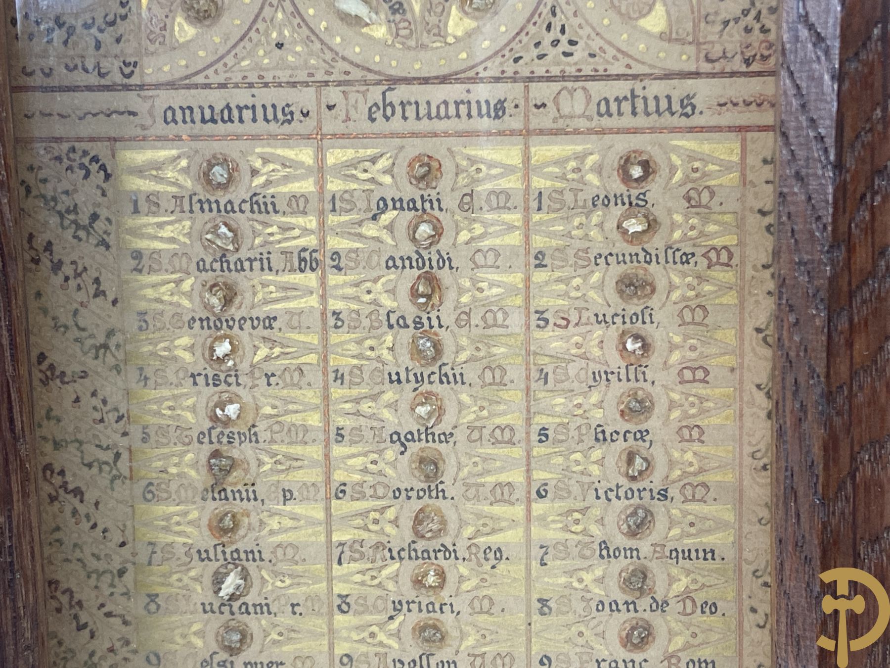Relikwie met 12 maanden van het jaar en elke dag een relikwie van de verschillende heiligen gevat in eikenhouten triptiek bovenaan versierd met ajourwerk en vooraan met lakzegels
