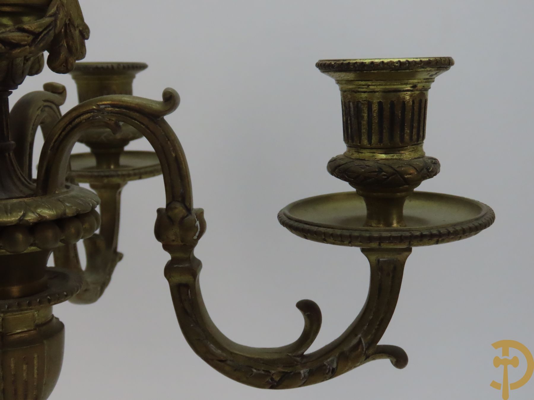 Paar bronzen Louis XVI vierarmige kandelaars bezet met toorts bovenaan