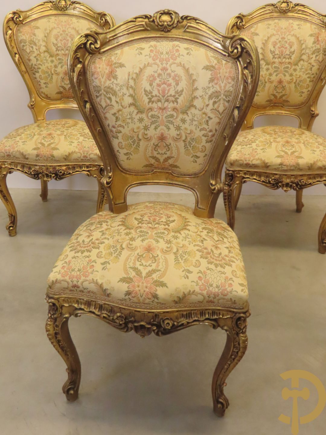 Uitzonderlijke vergulde Louis XV eetkamer bestaande uit vijfdeursdressoir met voluutvormige accanthusranken en rocailles, beschilderd met bloemenmotieven en centraal tafererel met hoornen des overvloeds + bijhorende spiegel vergulde tafel op voluutvormige poten met zes bijhorende stoelen + vitrine met accanthusranken en centrale deur, op voluutvormige poten