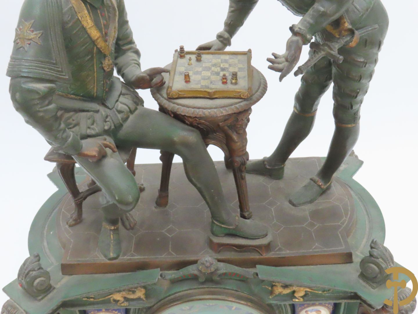 Driedelige kunstbronzen garnituur bestaande uit pendule met paar schakende edelheren, bezet met kariatiden - geflankeerd door paar driearmige kandelaars gehouden door 2 edelheren