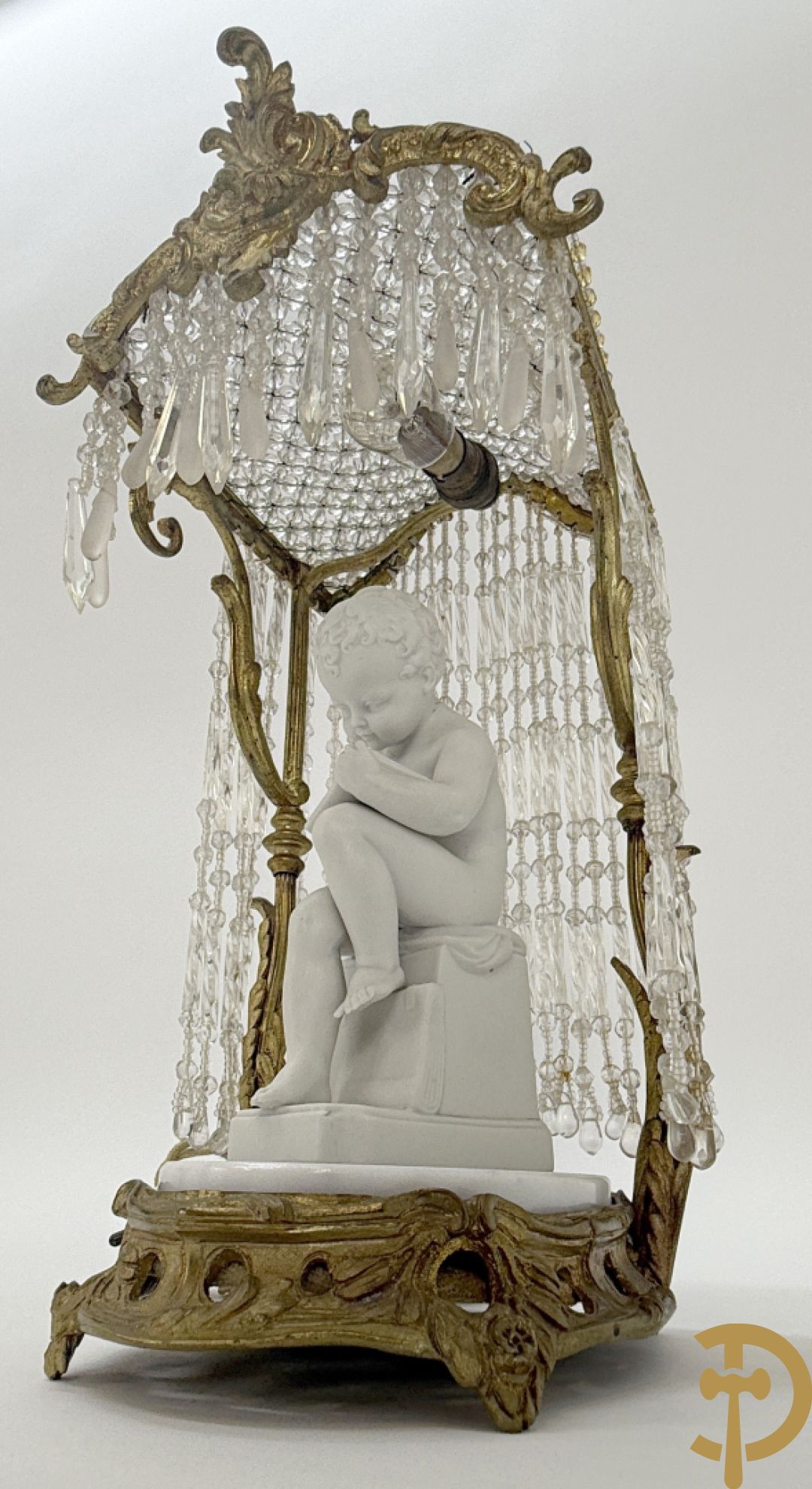 Biscuitbeeld van schrijvende cupido onder bronzen dakje met kristallen bellen bezet - op marmeren sokkel gemonteerd