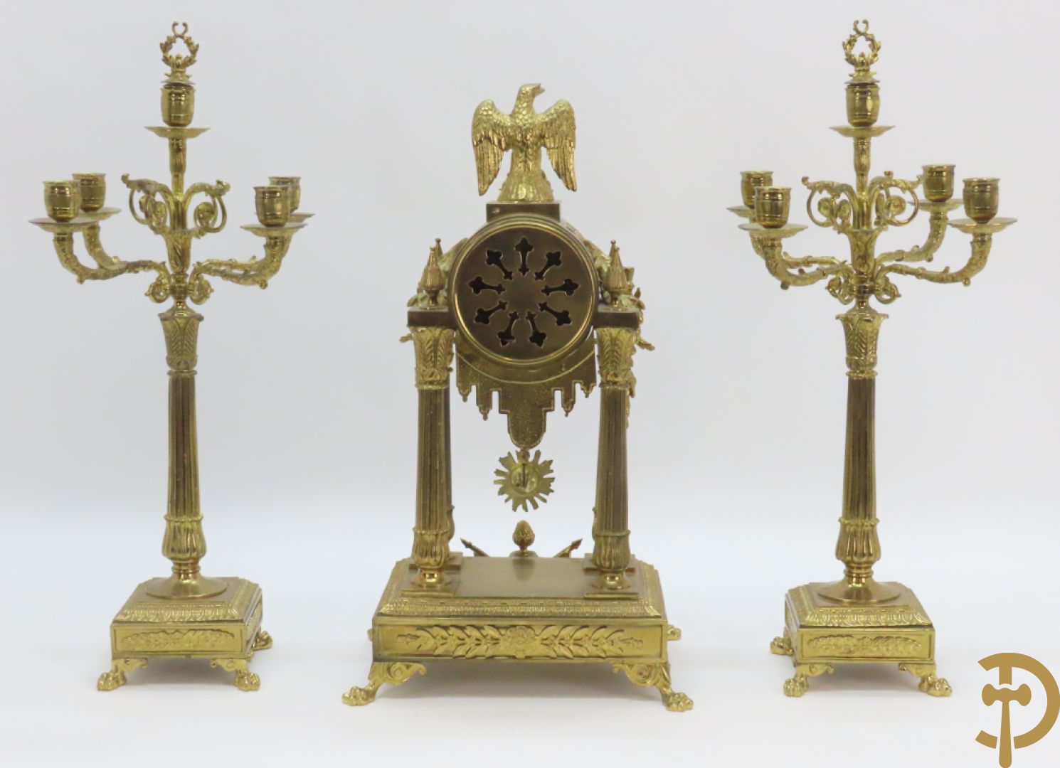 Driedelige bronzen garnituur bestaande uit middenstuk met 4 gecanneleerde zuilen en adelaar bezet + paar kandelaars