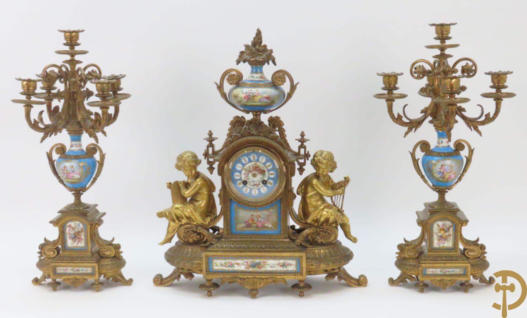 Driedelige bronzen garnituur bezet met Sèvres porselein bestaande uit pendule geflankeerd door paar cupido
