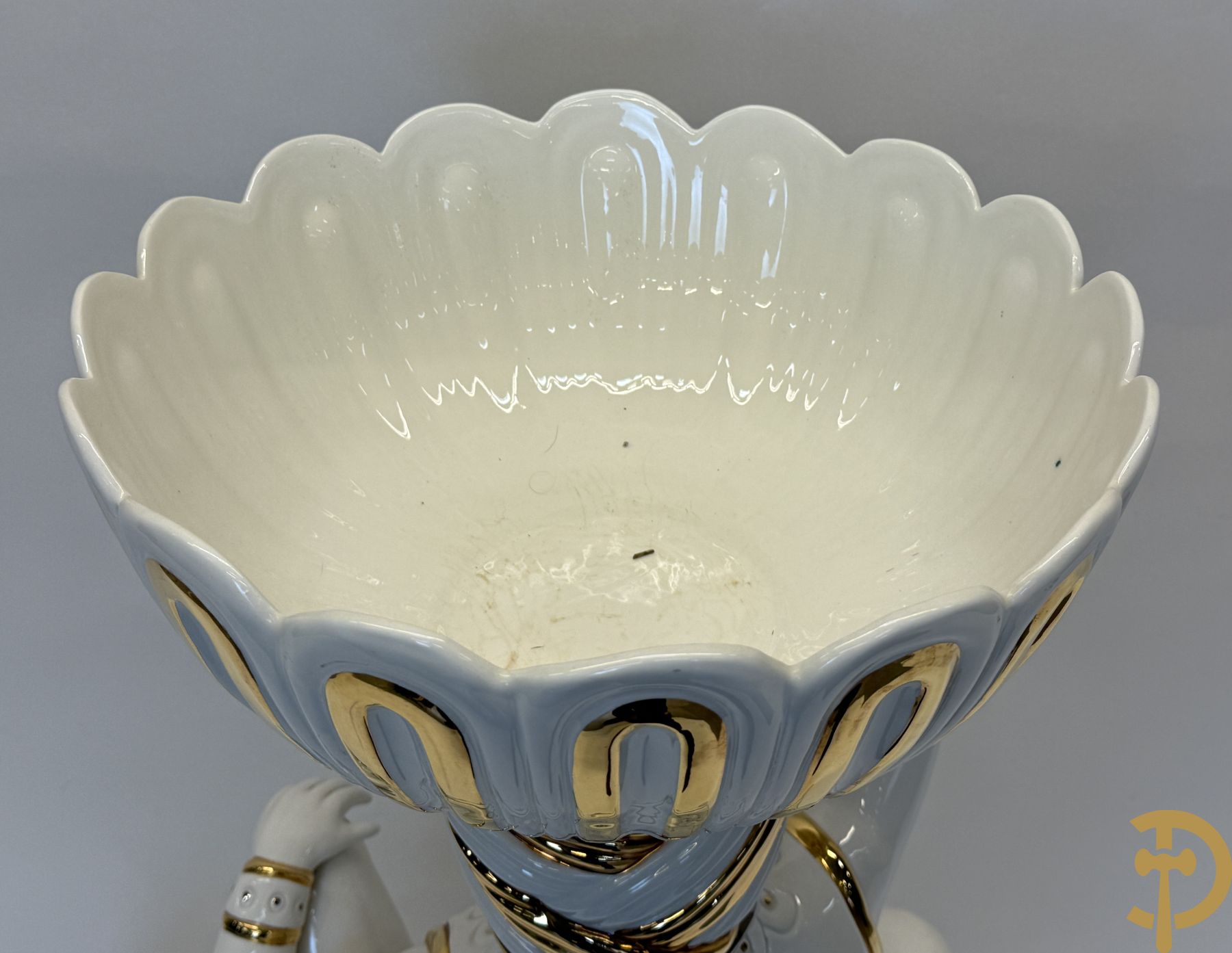 Porseleinen sierbeeld van olifant als staander met daarboven jongeman met bloemencachepot