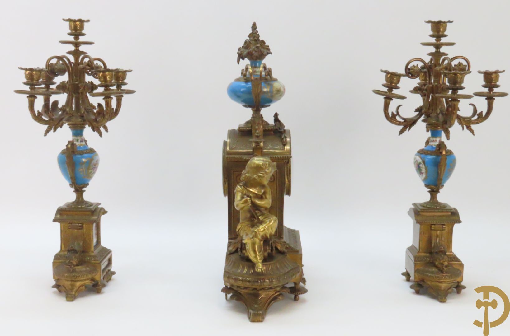 Driedelige bronzen garnituur bezet met Sèvres porselein bestaande uit pendule geflankeerd door paar cupido