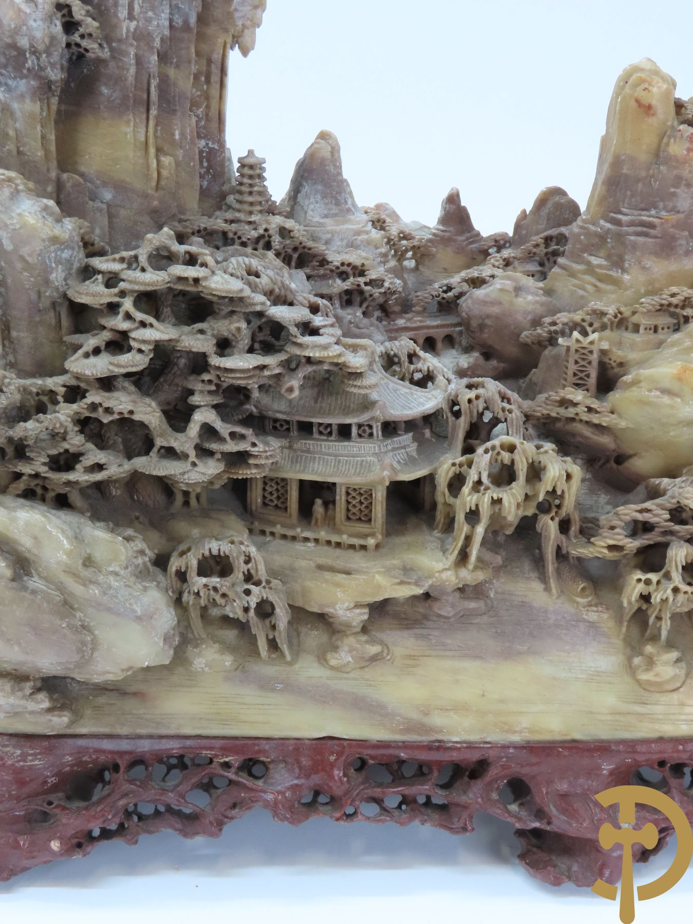Speksteensculptuur met Aziatisch huizenzicht tussen de rotsen