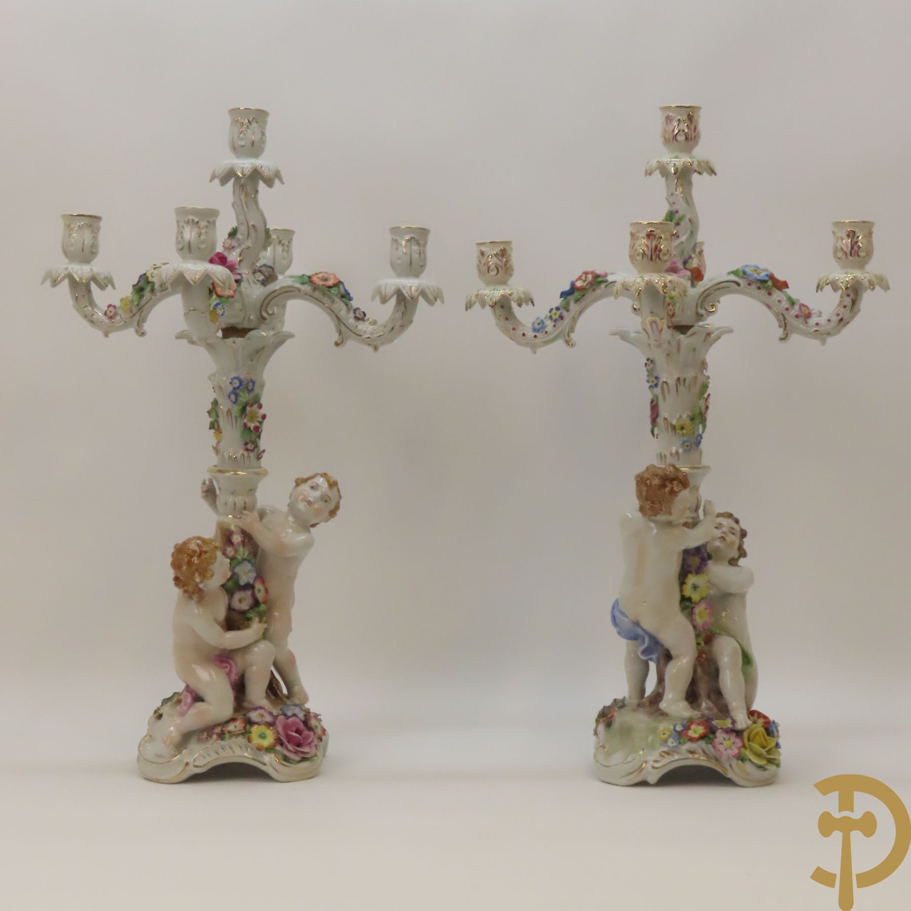Twee porseleinen vijfarmige kandelaars met cupido