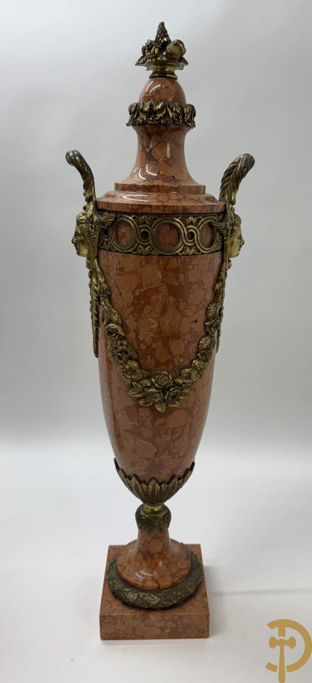 Paar oranje/rode marmeren cassolettes, zijdelings bezet met dameshoofden dragende een guirlande van bloemen - bovenaan met bloementroffee