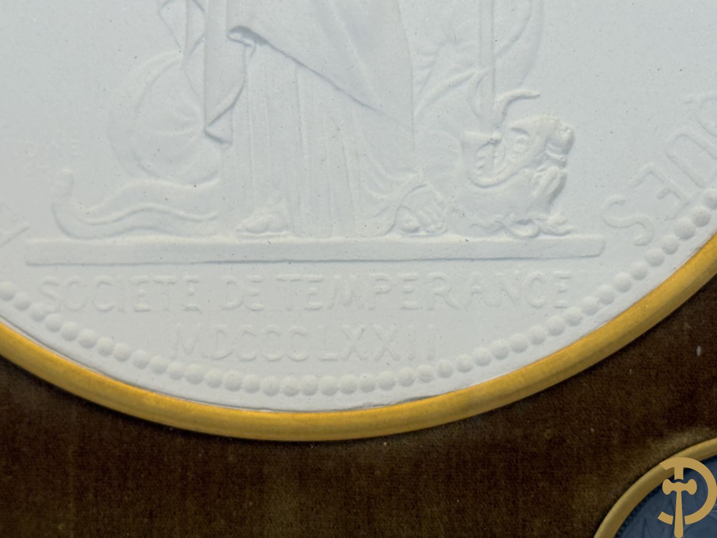 Kader met twee porseleinen plakkettes en 3 munten van Oudiné Eugène André