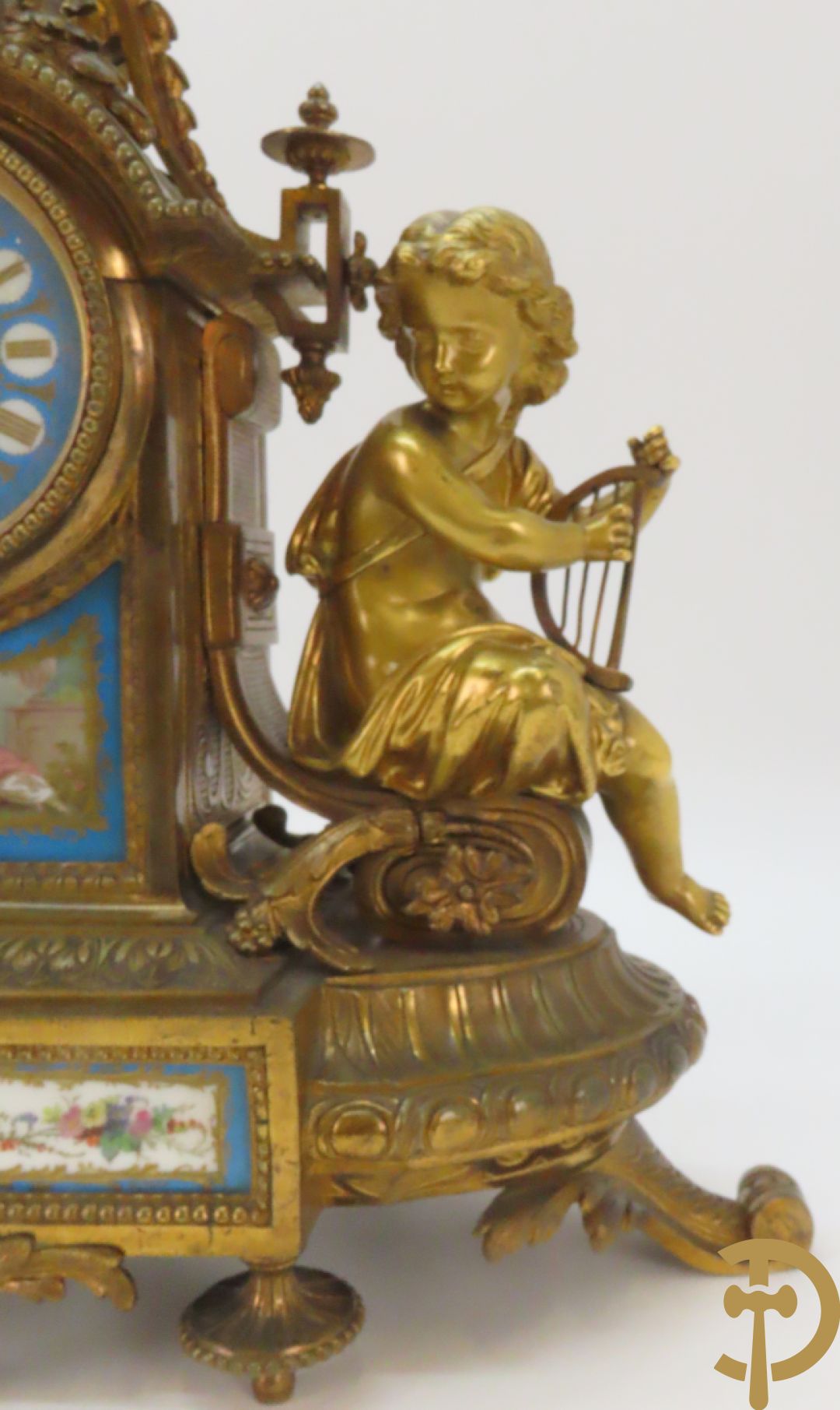 Driedelige bronzen garnituur bezet met Sèvres porselein bestaande uit pendule geflankeerd door paar cupido