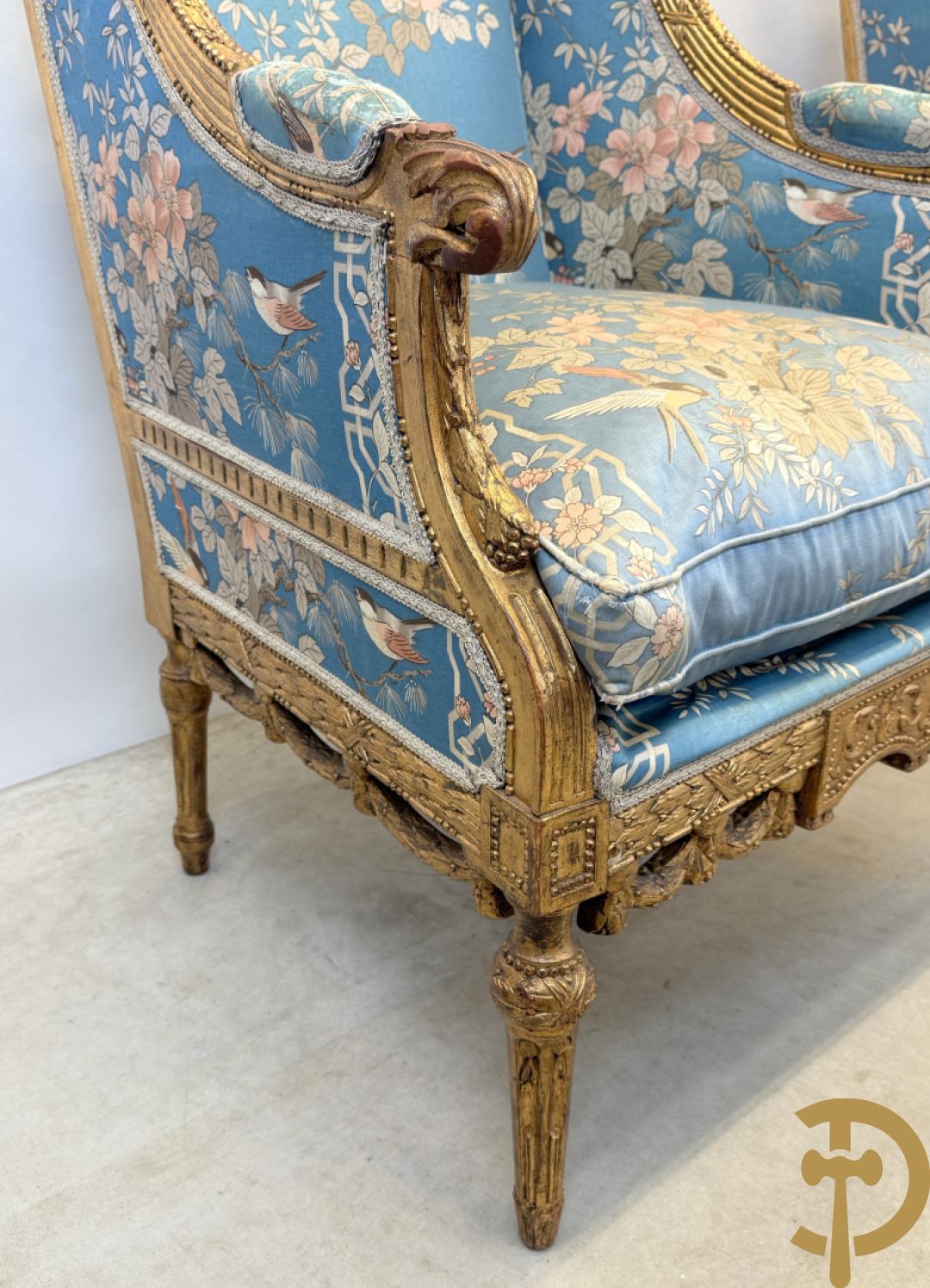 Twee vergulde bergères met gesculpteerde accanthusranken en guirlandes