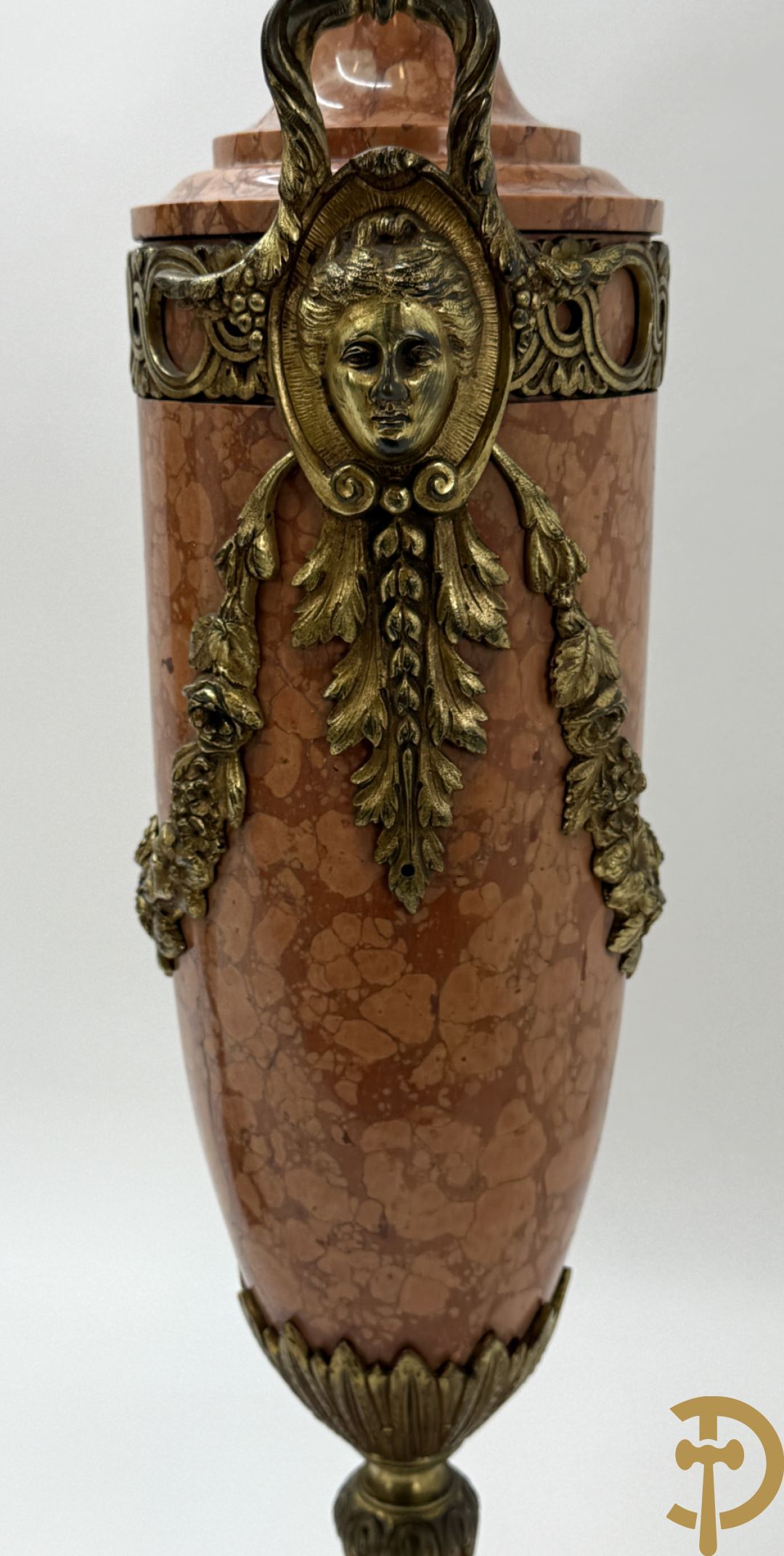 Paar oranje/rode marmeren cassolettes, zijdelings bezet met dameshoofden dragende een guirlande van bloemen - bovenaan met bloementroffee