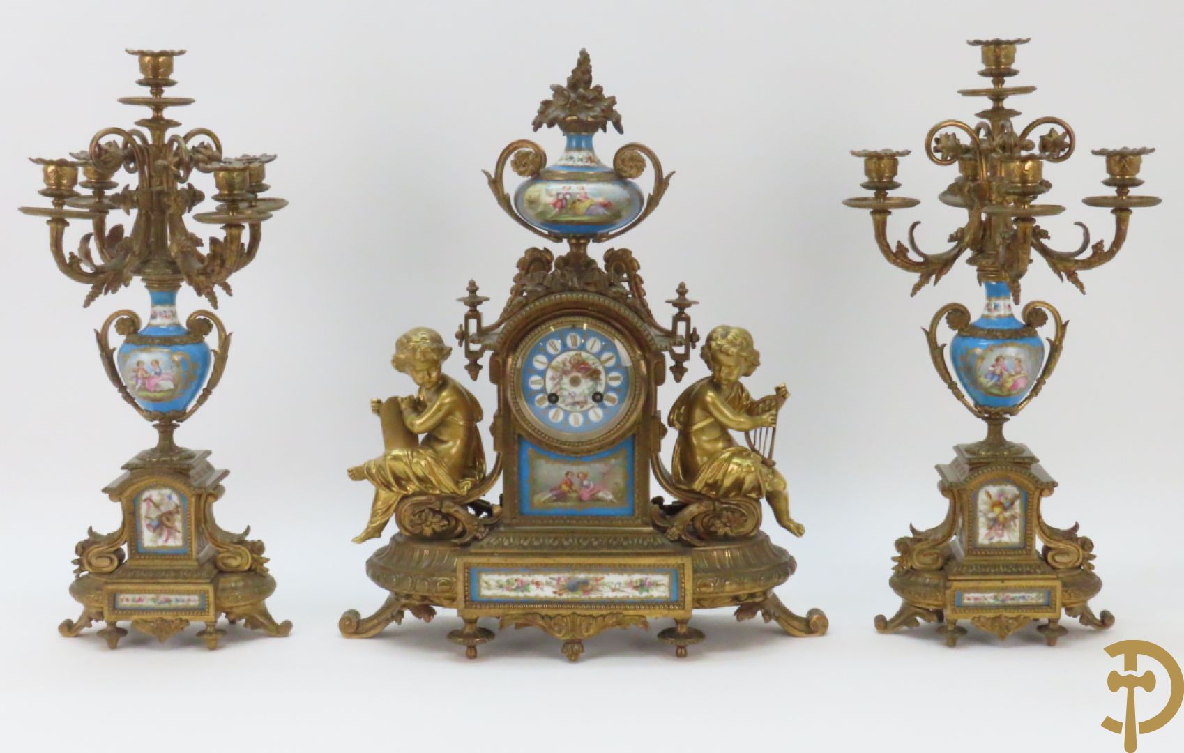 Driedelige bronzen garnituur bezet met Sèvres porselein bestaande uit pendule geflankeerd door paar cupido