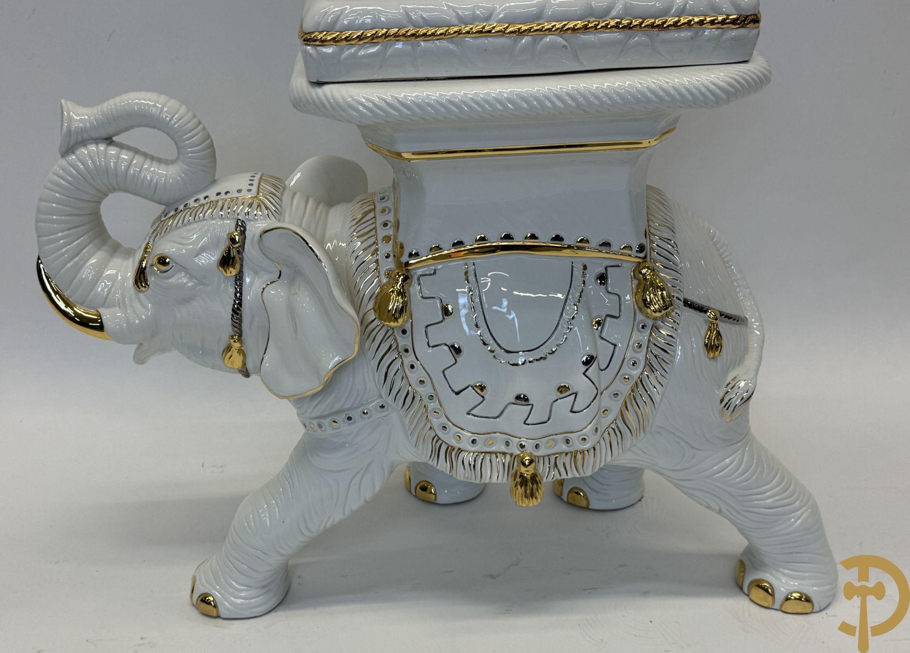 Porseleinen sierbeeld van olifant als staander met daarboven jongeman met bloemencachepot