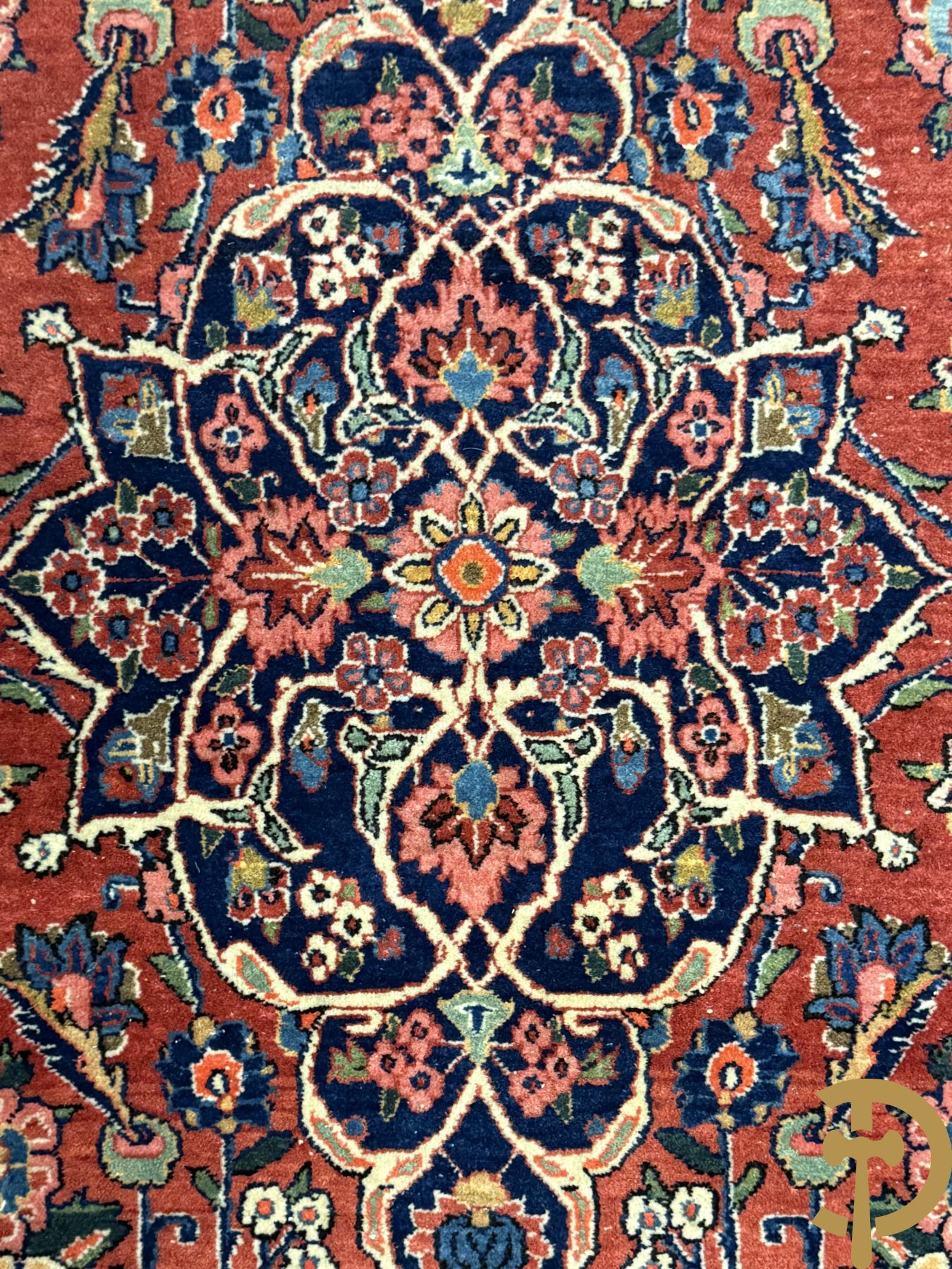 Oosters handgeknoopt tapijt met bloemenmotieven op rode fond