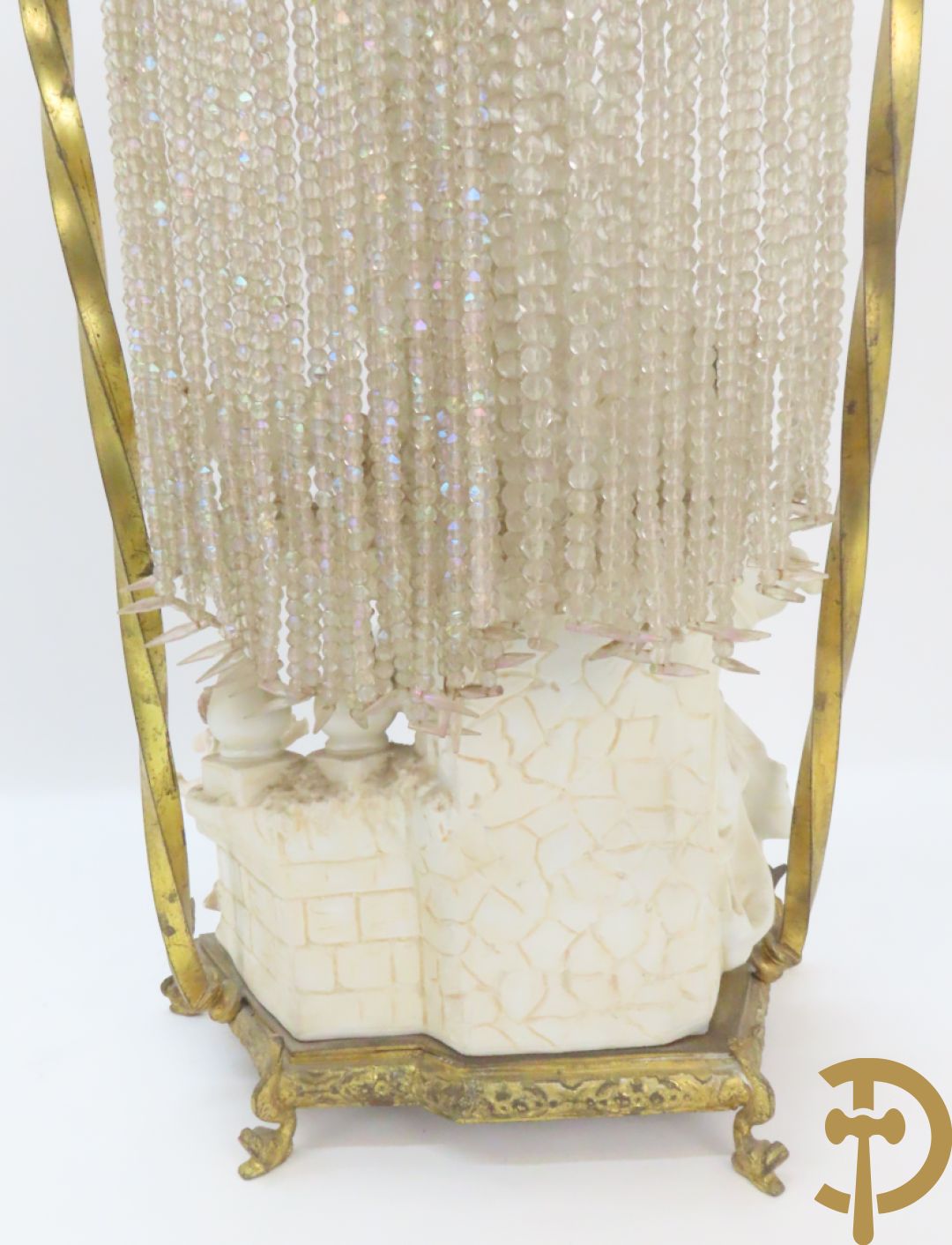 Lieftallig biscuit van romantisch koppel bij amfoor met kleine neergezeten cupido onder koperen baldakijn met kristallen belletjes