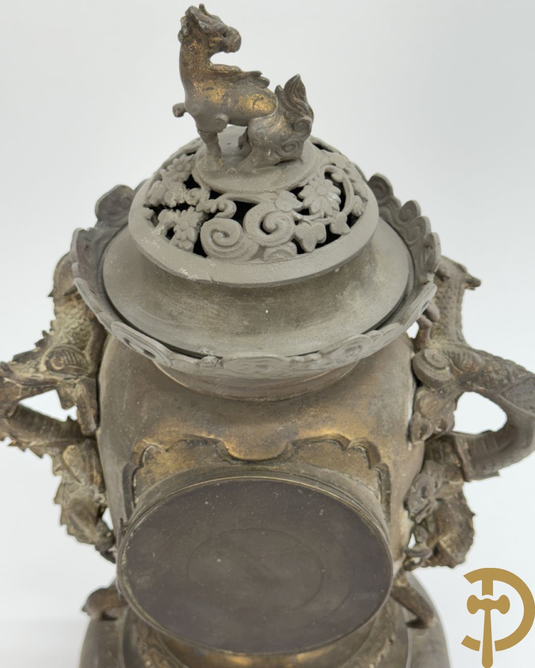 Aziatische pendule in zamak, zijdelings bezet met drakendecor en bovenaan met mythologisch figuur