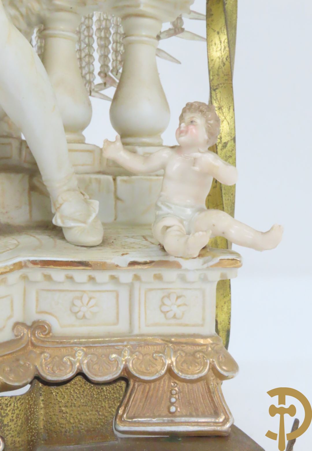 Lieftallig biscuit van romantisch koppel bij amfoor met kleine neergezeten cupido onder koperen baldakijn met kristallen belletjes