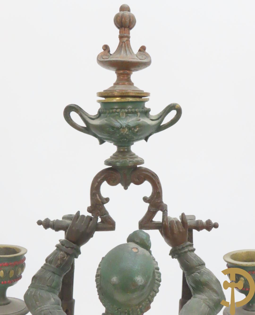 Driedelige kunstbronzen garnituur bestaande uit pendule met paar schakende edelheren, bezet met kariatiden - geflankeerd door paar driearmige kandelaars gehouden door 2 edelheren