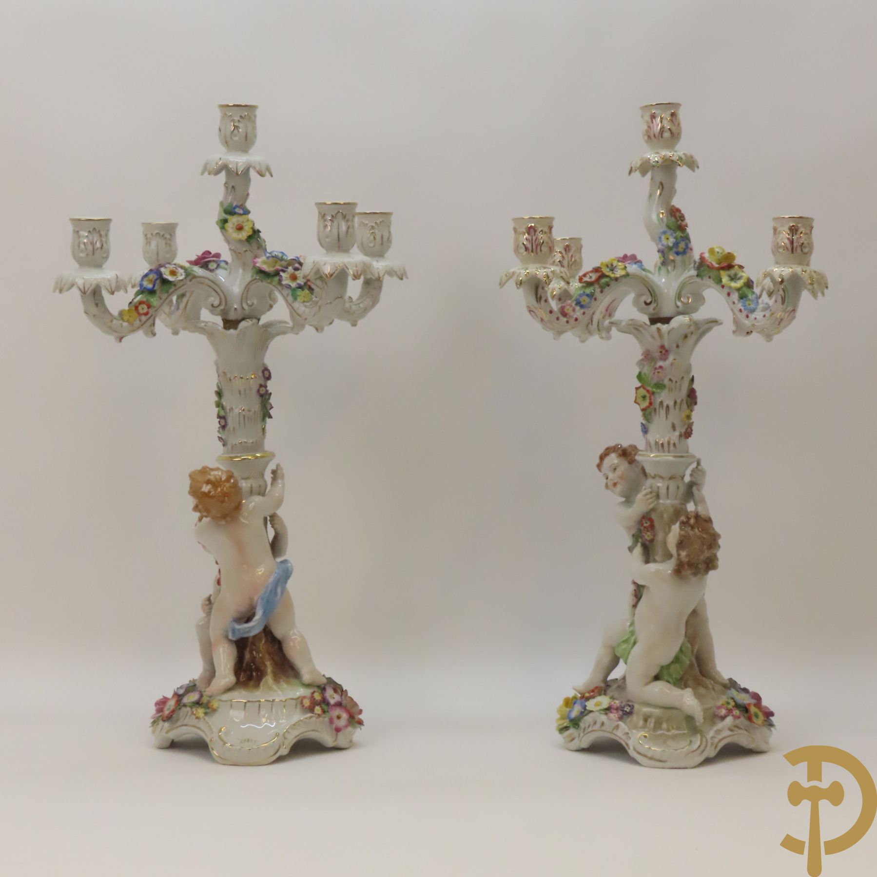 Twee porseleinen vijfarmige kandelaars met cupido
