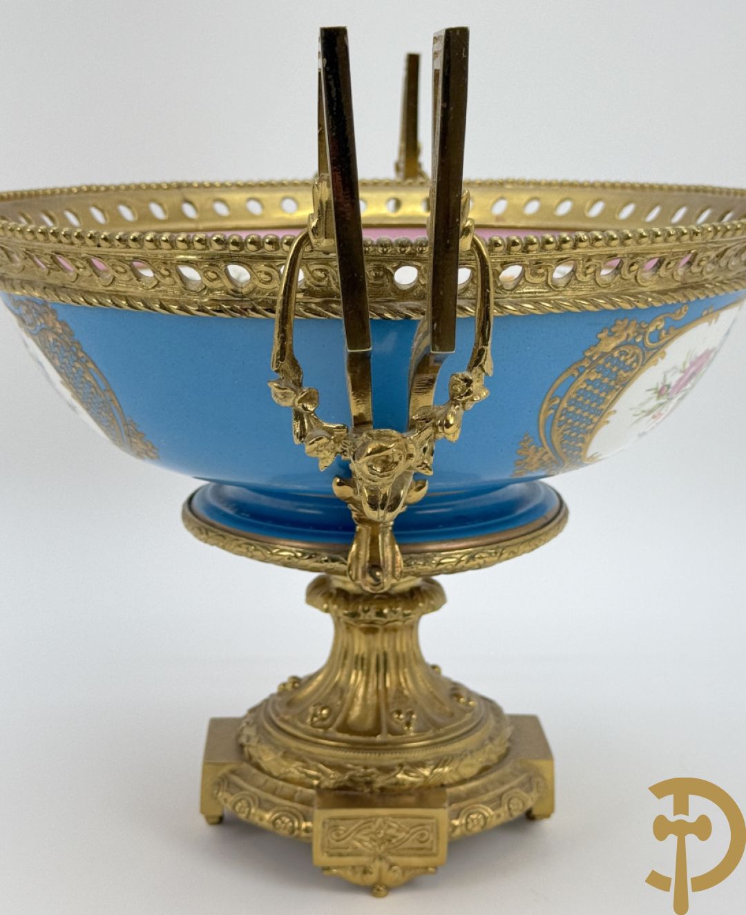 Porseleinen coupe met centraal tafereel en omringd met bloemendecor, gevat in bronzen houder