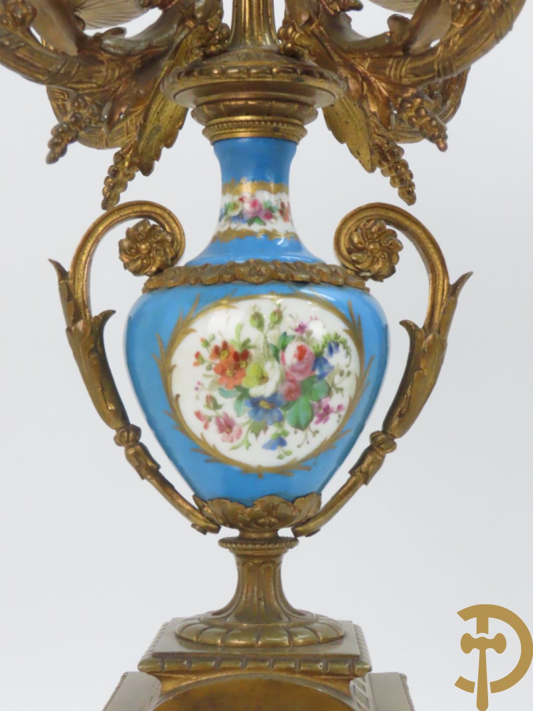 Driedelige bronzen garnituur bezet met Sèvres porselein bestaande uit pendule geflankeerd door paar cupido