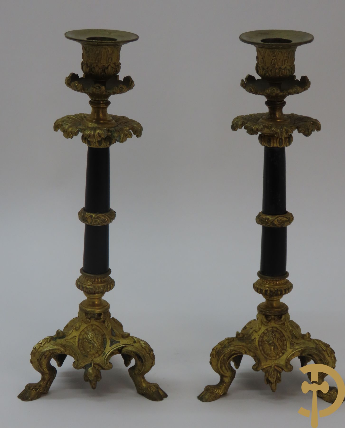 Paar vuurvergulde bronzen kandelaars met zwarte stijl op 3 bokkepootjes