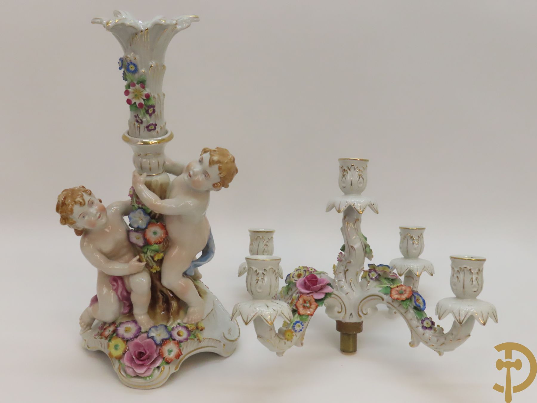 Twee porseleinen vijfarmige kandelaars met cupido