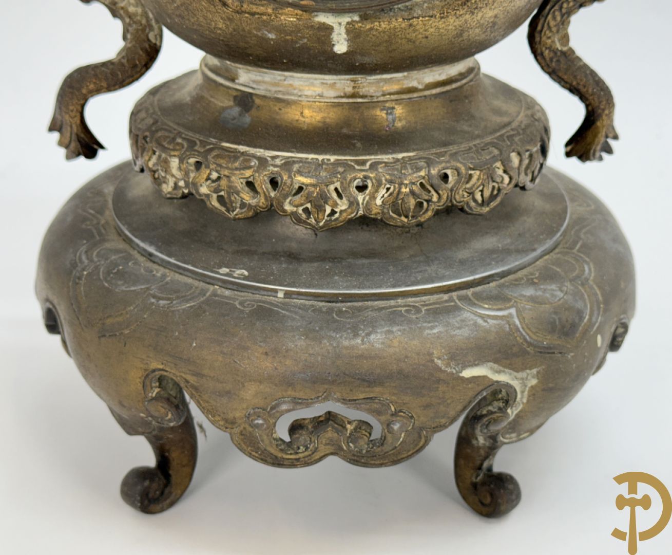 Aziatische pendule in zamak, zijdelings bezet met drakendecor en bovenaan met mythologisch figuur