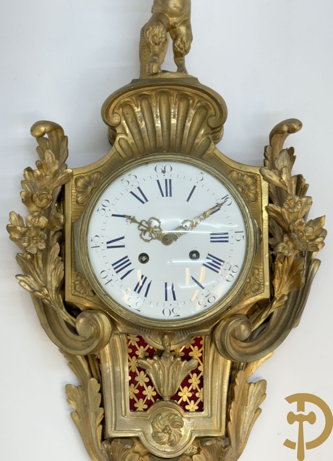 Bronzen muurkartel Louis XV stijl met bloemenmotieven en bovenaan bezet met faune met triangle, Molle Paris getekend binnenin op uurwerk