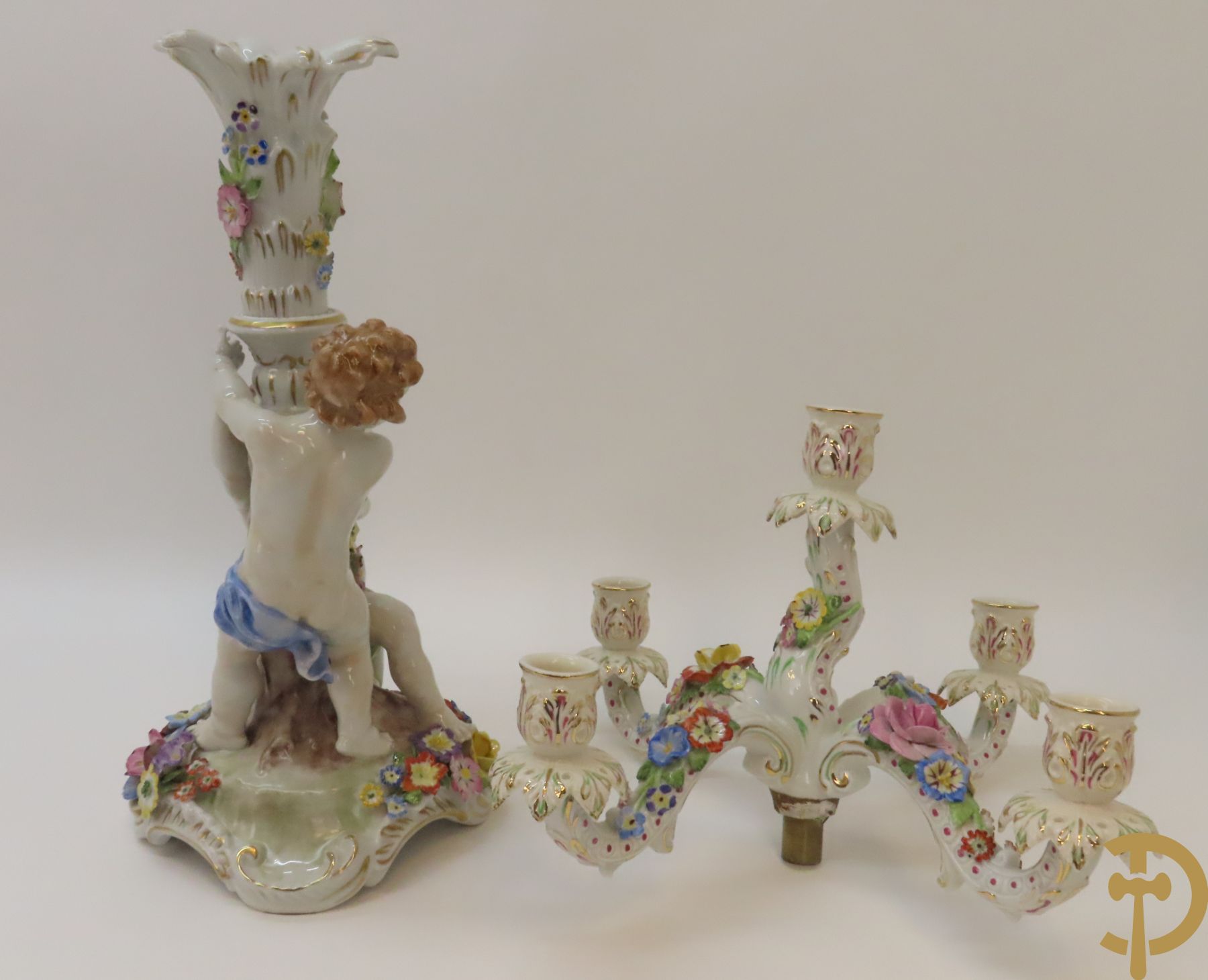 Twee porseleinen vijfarmige kandelaars met cupido